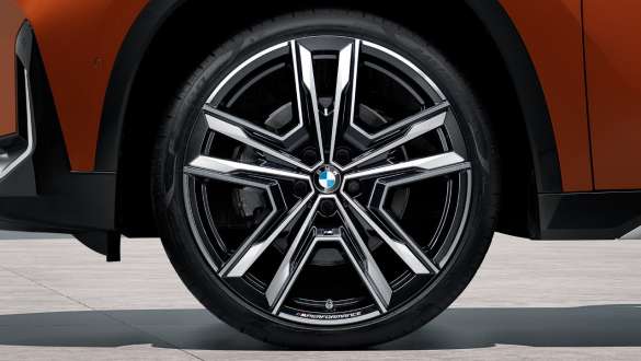 Caja portaequipajes para techo con cierre y apertura por ambos lados en negro/plata titanio, con una capacidad de 420 litros; adecuada para cualquier sistema portaequipajes para techo de BMW. Llanta de aleación ligera M Performance de 21 pulgadas con radios dobles estilo 877 M, en bicolor Jet Black, fresado brillante