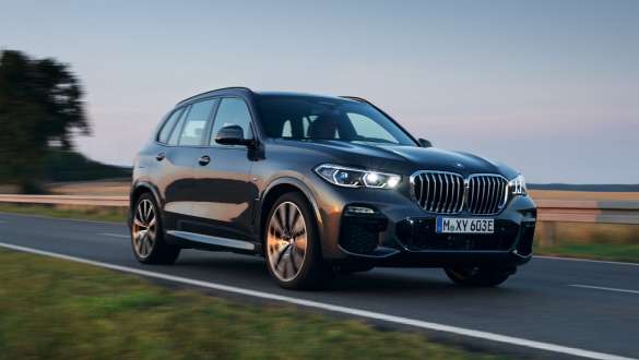 Híbrido enchufable BMW X5 xDrive45e G05, vista de tres cuartos del frontal, circulando Híbrido enchufable BMW X5 xDrive45e G05 vista de tres cuartos del frontal, circulando por la carretera