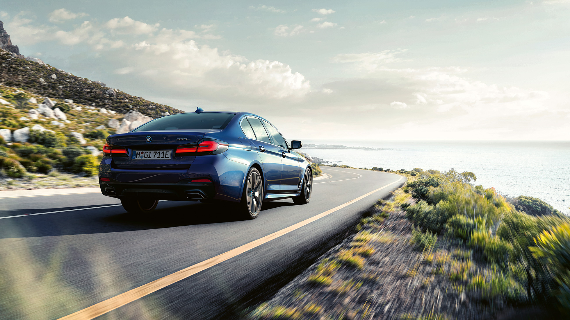 Dinámica de conducción BMW Serie 5 Sedan G30 Dinámica de conducción BMW Serie 5 Sedan G30 Vista trasera de tres cuartos de conducción azul fítico