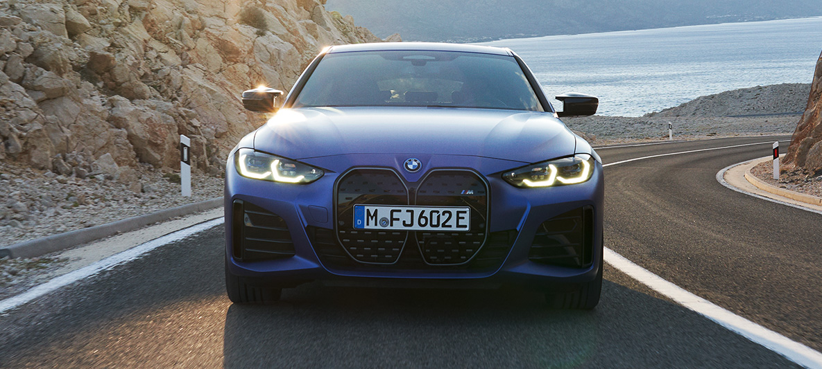 Vista del frontal BMW i4 M50 G26 2021, en marcha BMW i4 M50 G26 2021 M Portimao Blau metalizado, vista del frontal, en marcha en carretera