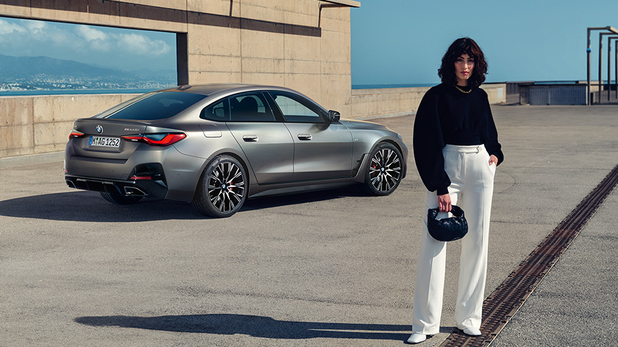 BMW M440i xDrive Gran Coupé G26 2021 Vista de tres cuartos de la zaga con modelo BMW M440i xDrive Gran Coupé G26 2021 Frozen Pure Grey metalizado Vista de tres cuartos de la zaga con modelo