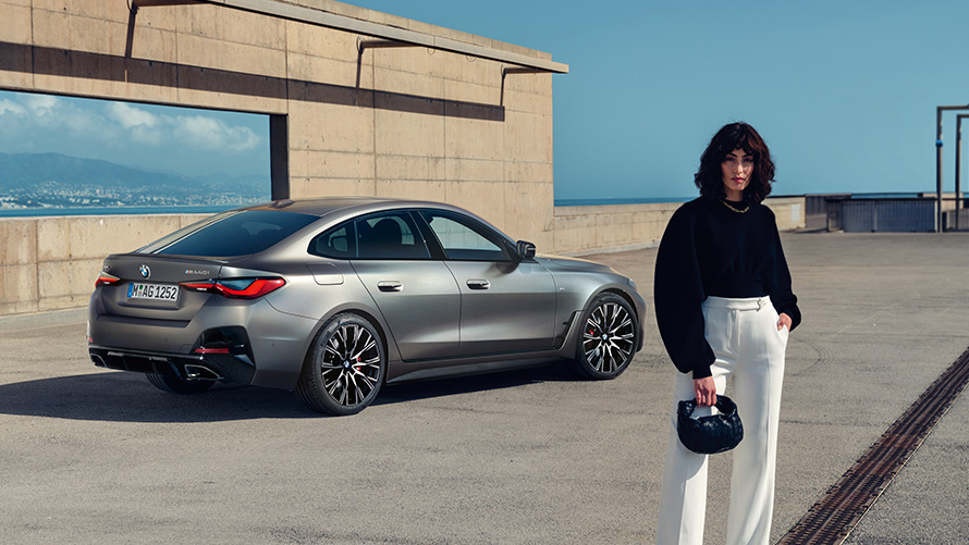 BMW M440i xDrive Gran Coupé G26 2021 Vista de tres cuartos de la zaga con modelo BMW M440i xDrive Gran Coupé G26 2021 Vista de tres cuartos de la zaga con modelo