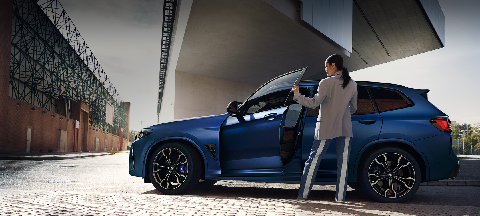 BMW X3 M Competition F97 LCI Renovación 2021 Vista lateral, parado BMW X3 M Competition F97 LCI Renovación 2021 BMW Frozen Portimao Blau metalizado, vista lateral, parado, con la puerta abierta y modelo femenina