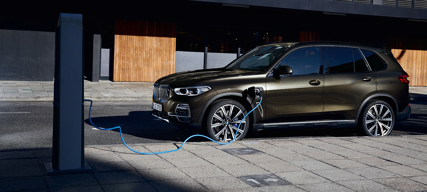 Híbrido enchufable BMW X5 xDrive45e G05 vista de tres cuartos del lateral Híbrido enchufable BMW X5 xDrive45e G05 vista de tres cuartos del lateral, carga