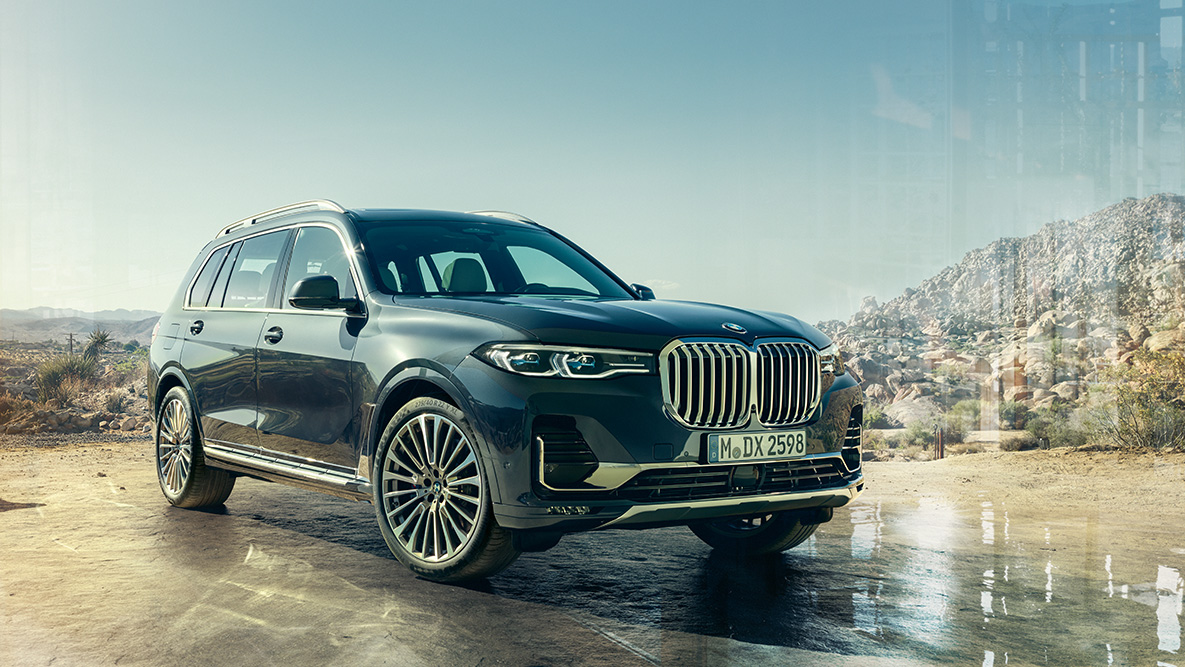 BMW X7 exterior, vista delantera de tres cuartos BMW X7 exterior: vista delantera de tres cuartos frente a un desierto