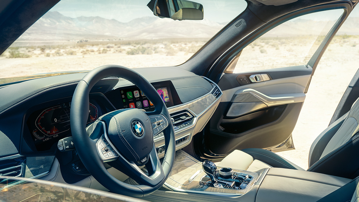 BMW X7 interior Interior del BMW X7: vista desde fuera hacia la primera fila de asientos con vista al volante, panel de instrumentos y asientos de piel