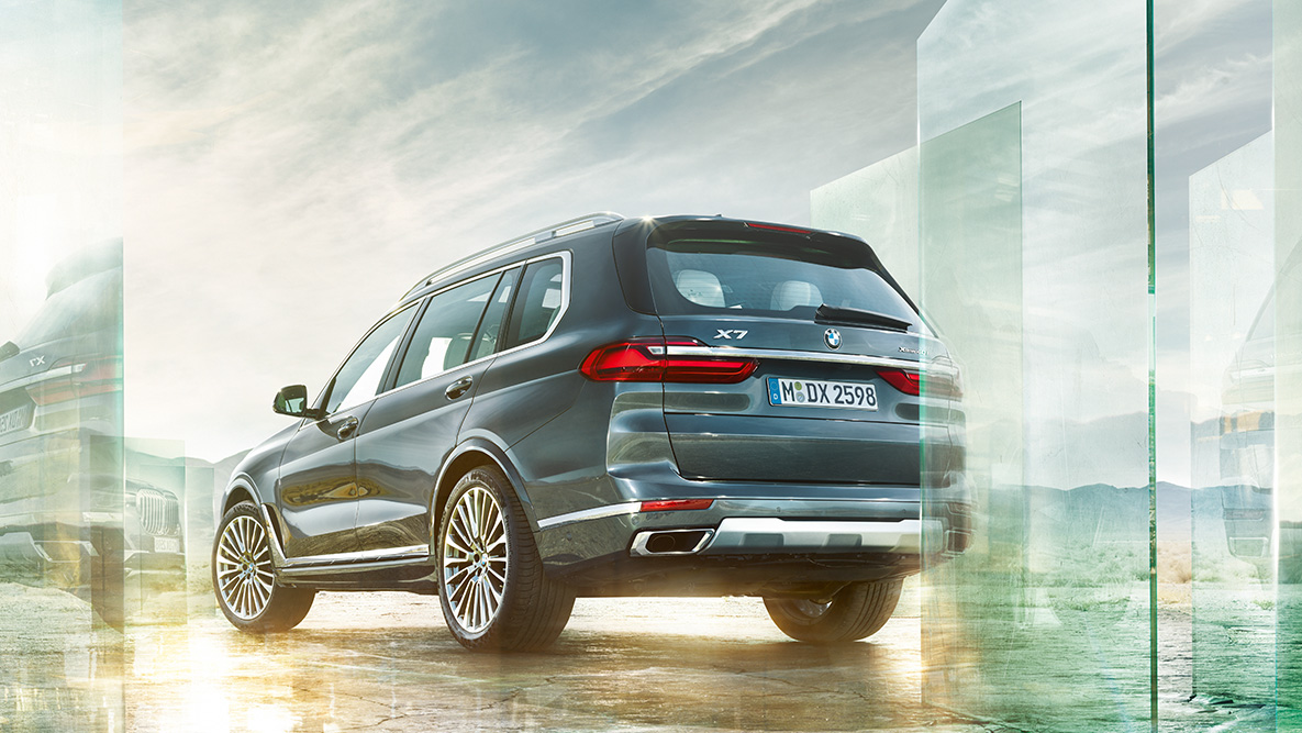 BMW X7 Comodidad y Dinámica de Conducción BMW X7 en vista trasera de tres cuartos con un fondo abstracto