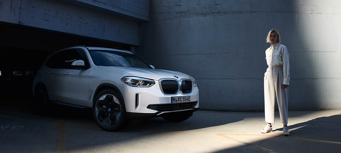 Mujer delante de BMW iX3 Mujer delante de BMW i3 BMW EfficientDynamics