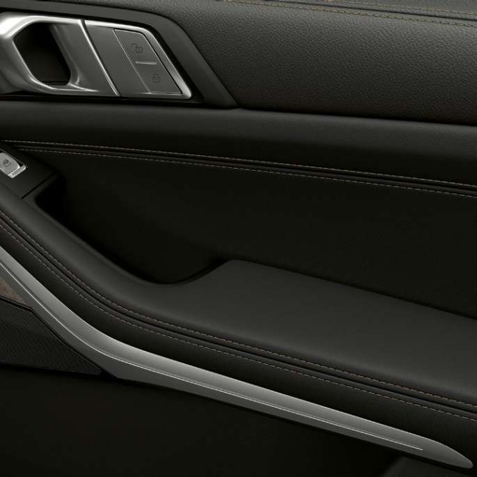 Acercamiento de la parte interior de la puerta del BMW X7 con características de equipamiento estándar